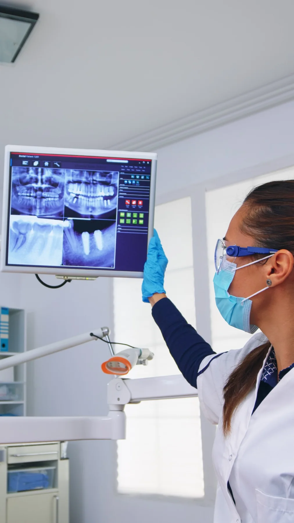 Profesional odontológica revisando radiografías digitales